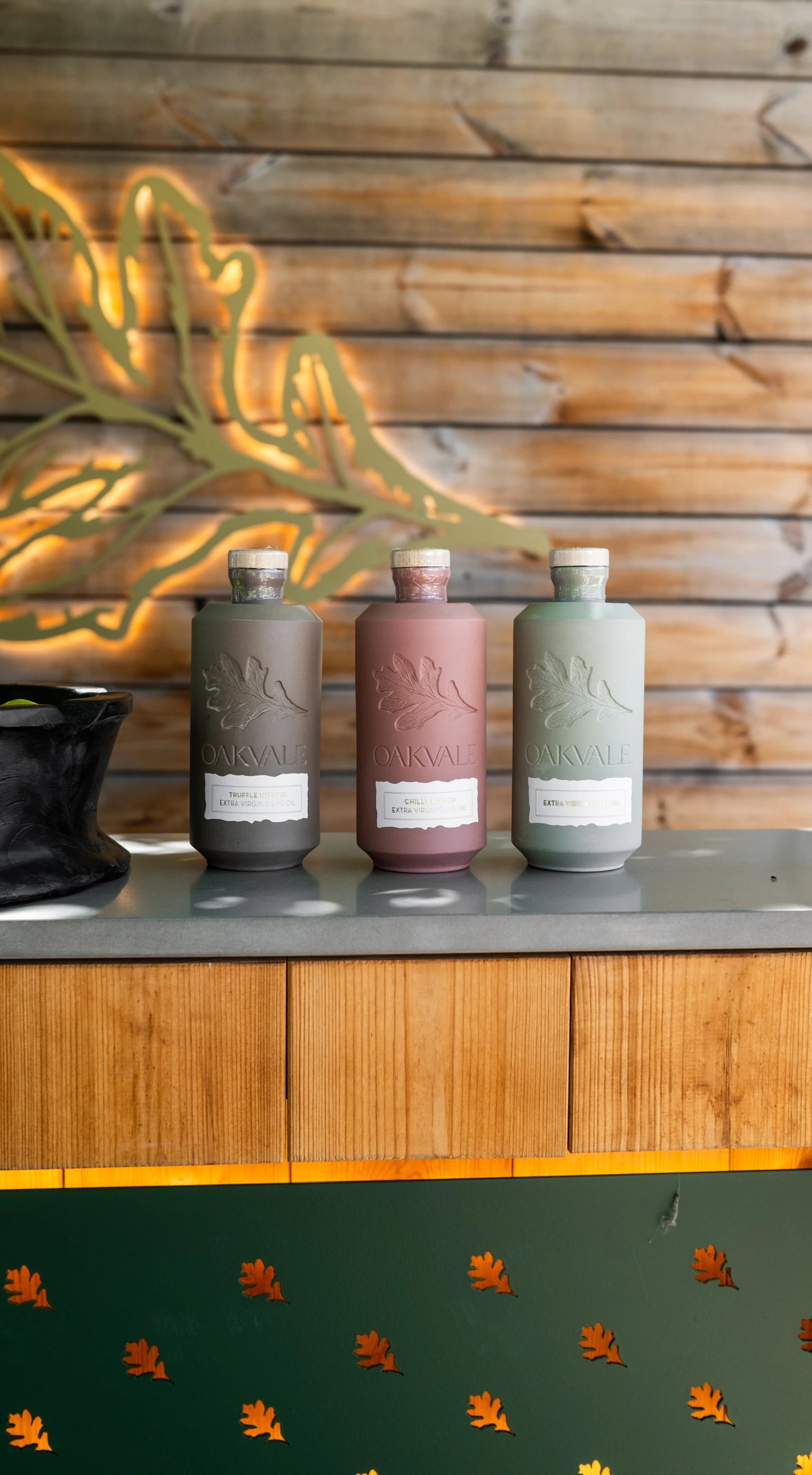 Three Oakvale olive oil bottles displayed at the pool bar
