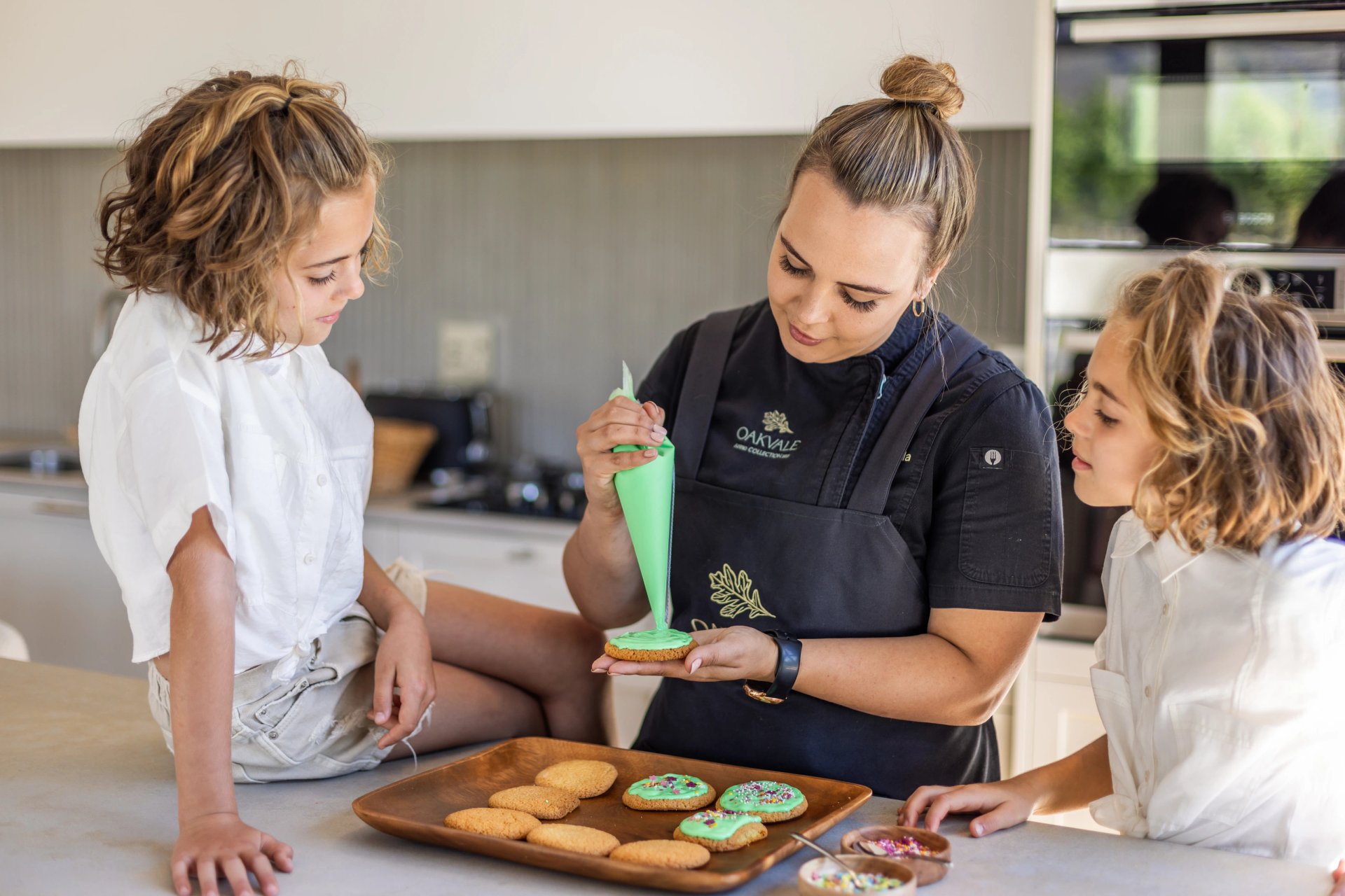 Chef and children decorating biscuits
