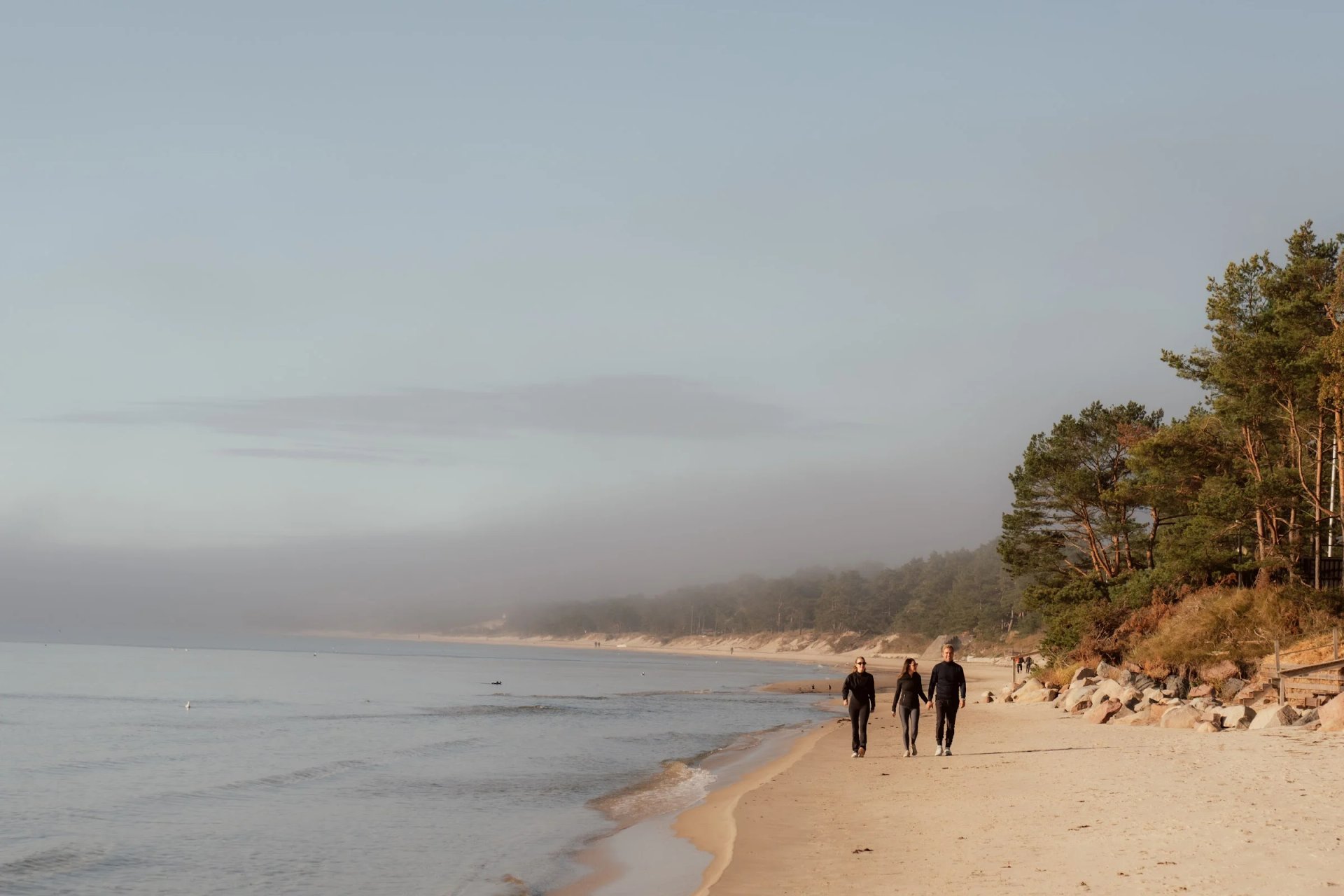 Guests walking along the sandy beach beside Villa Sand