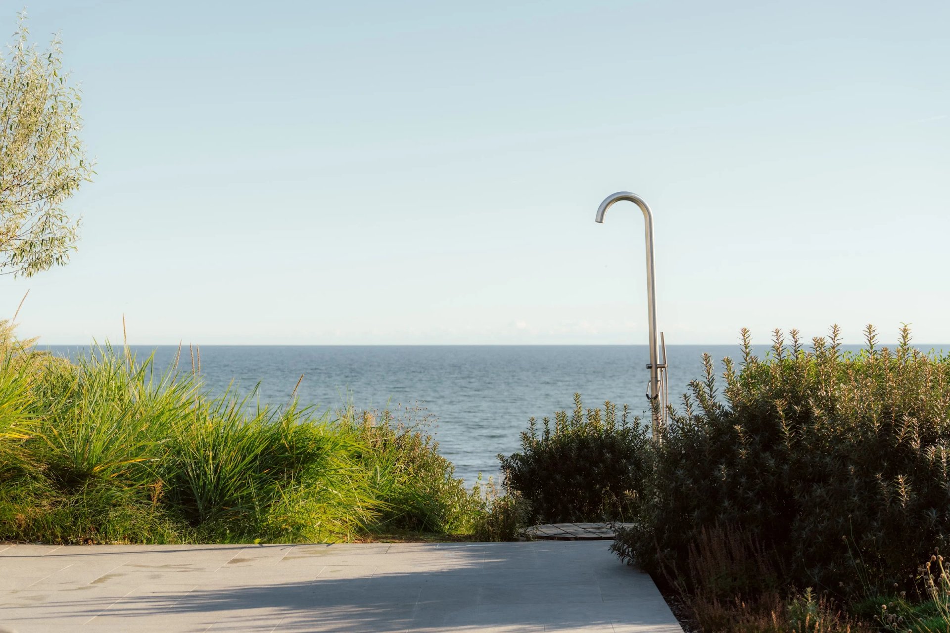 Outdoor shower and coastal planting overlooking the Baltic Sea at Villa Sand