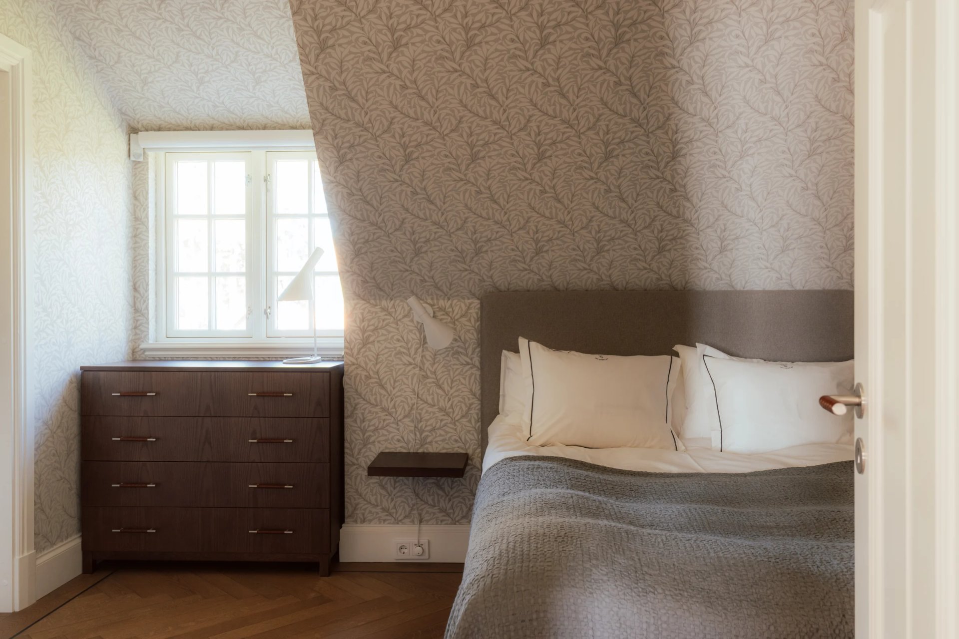 Guest bedroom with patterned wallpaper at Villa Sand