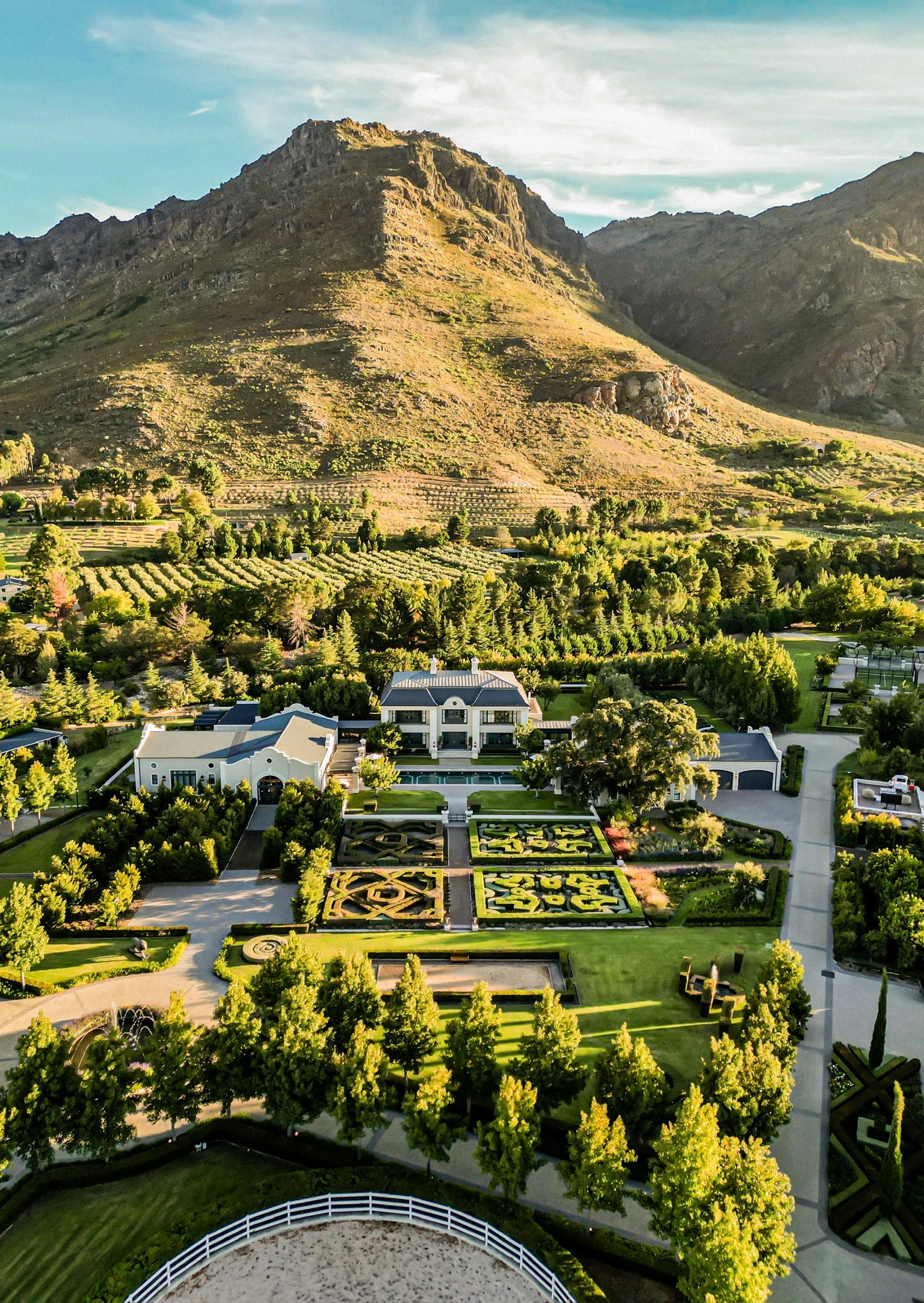 Aerial view of Oakvale Estate gardens and manor beneath the mountain