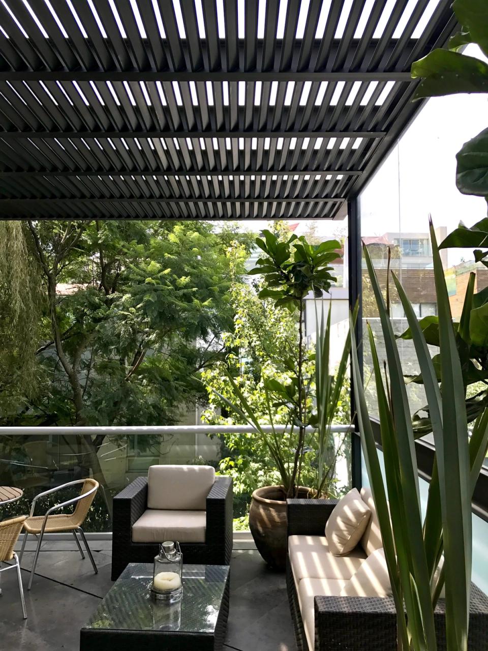 Terraza con pérgola de lamas y vista a los árboles