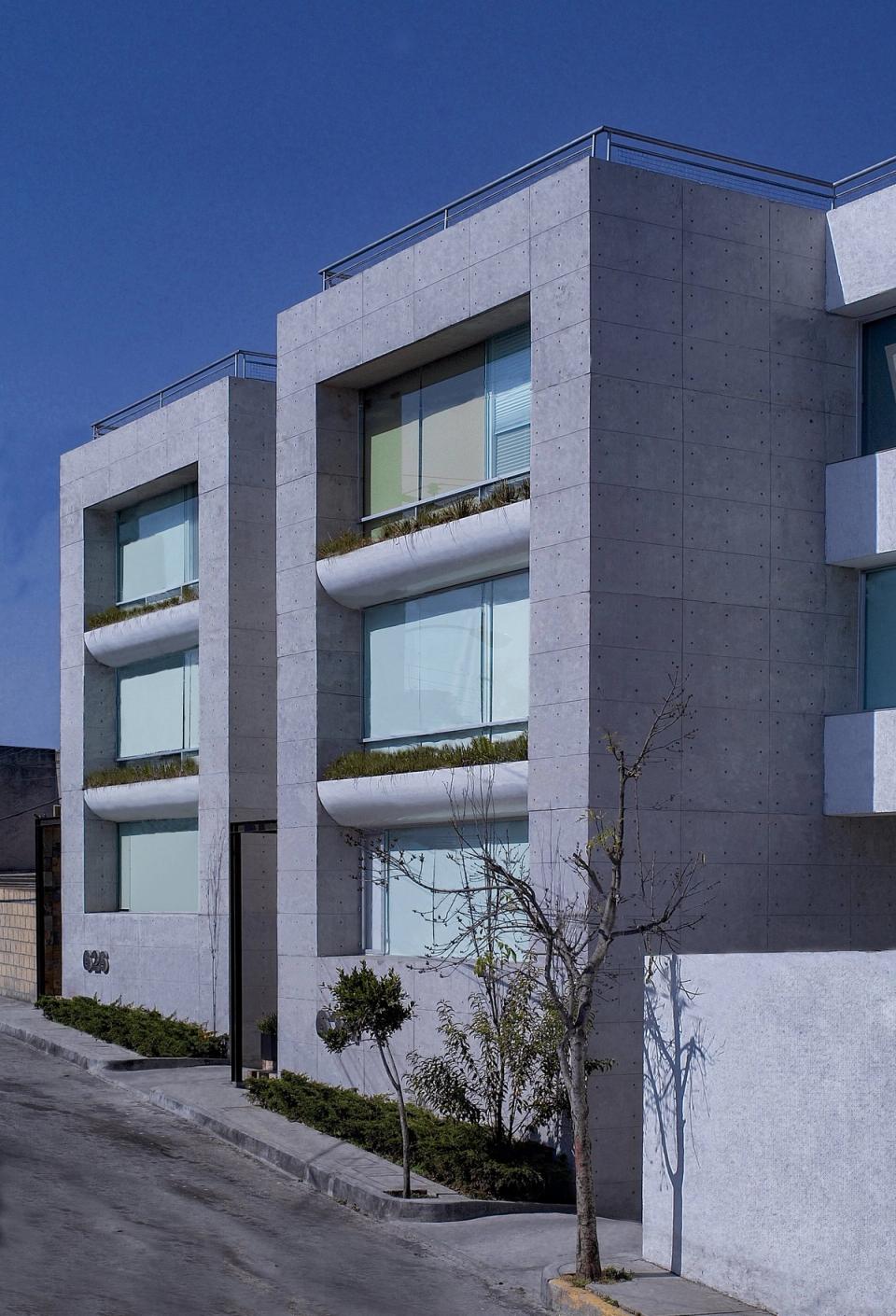 Fachada de concreto con ventanas corridas