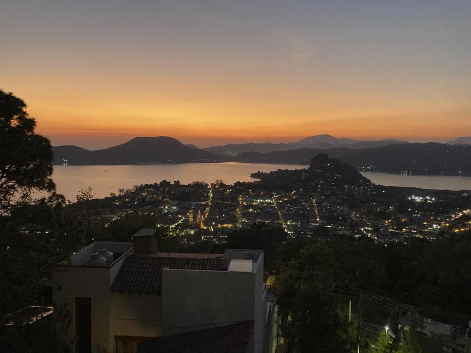 Vista nocturna del pueblo iluminado y el lago