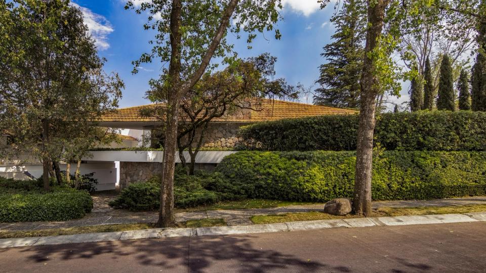La casa vista desde el jardín entre los árboles