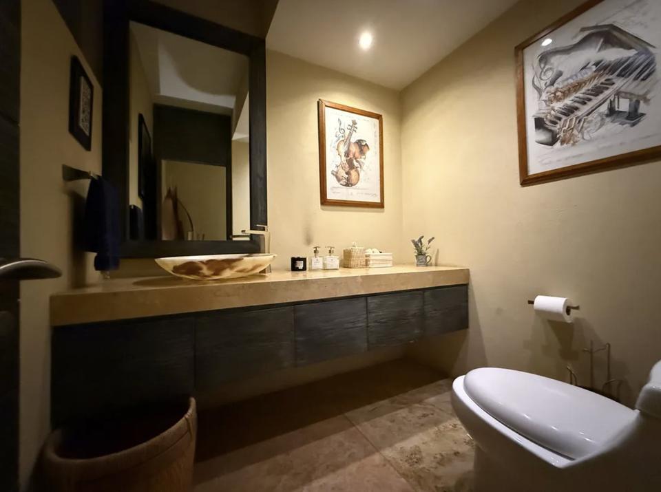 Baño con cubierta de piedra y mueble flotante de madera oscura