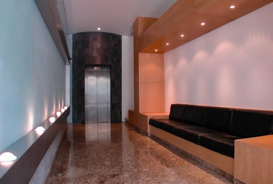 Vestíbulo de acceso con elevador y banca de piel