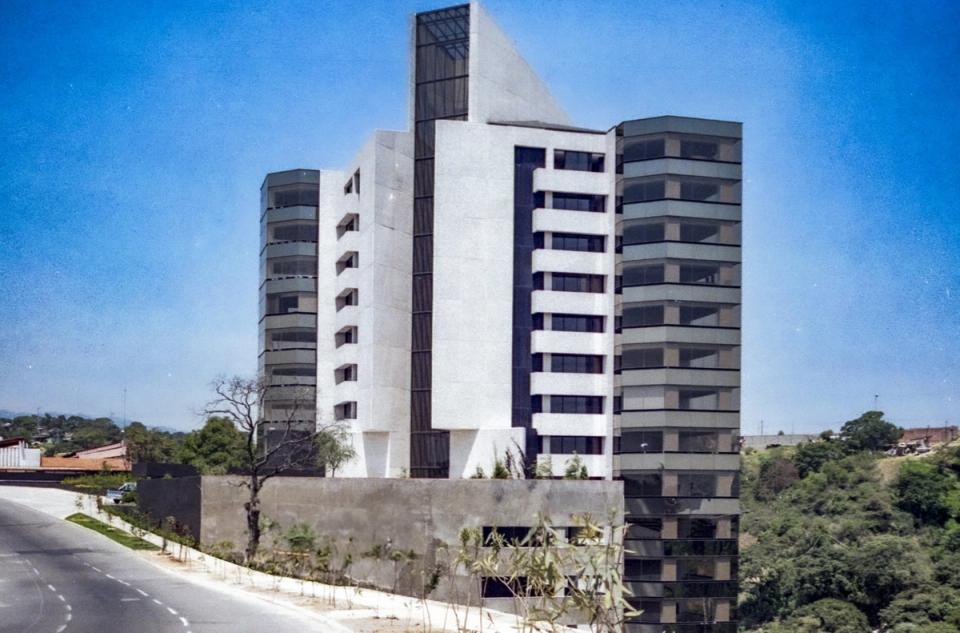 Torre de departamentos blanca sobre una colina