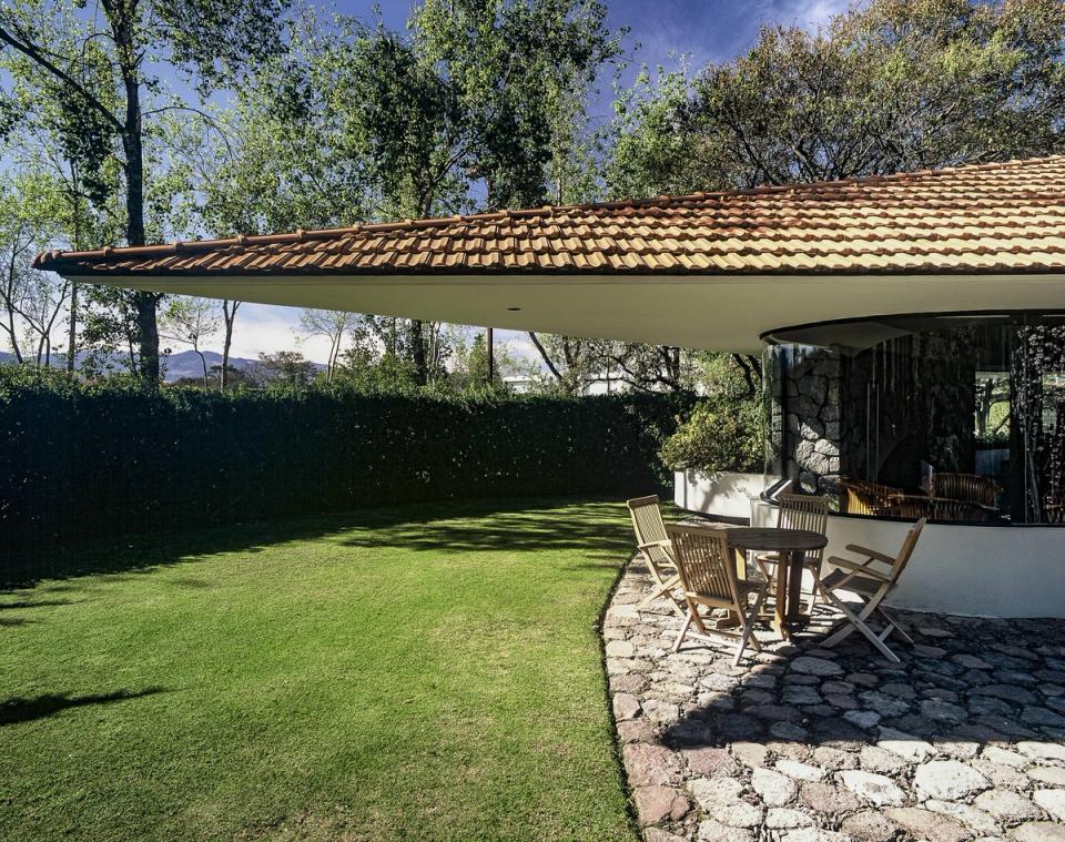 Jardín bajo el alero de la cubierta de teja