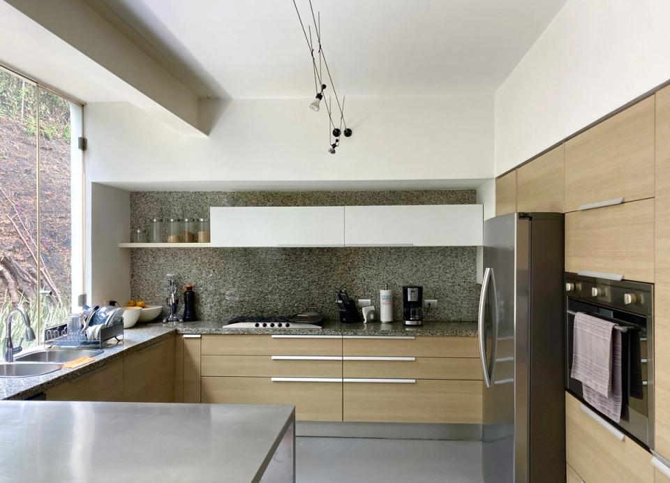 Cocina con gabinetes de madera clara e isla metálica