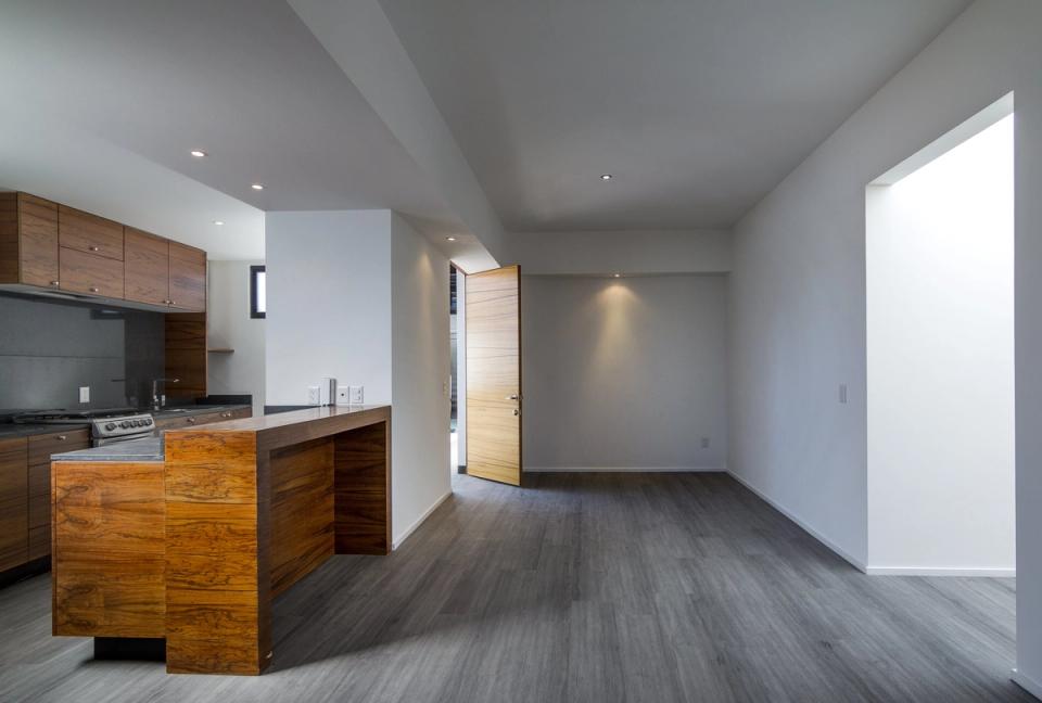 Cocina con isla de madera abierta a la estancia