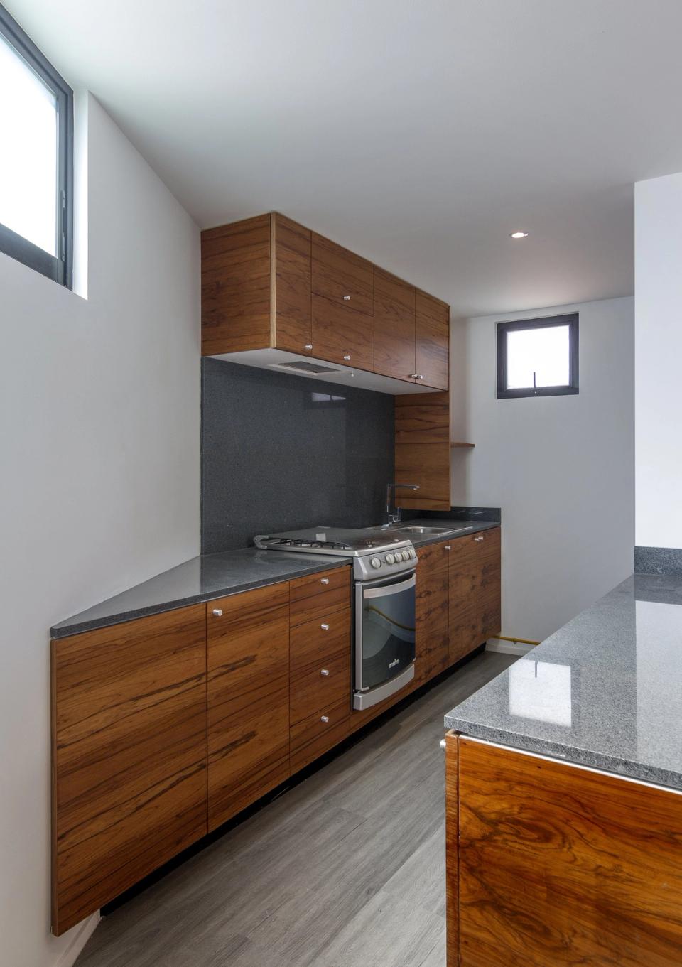 Cocina lineal con gabinetes de madera y cubierta gris