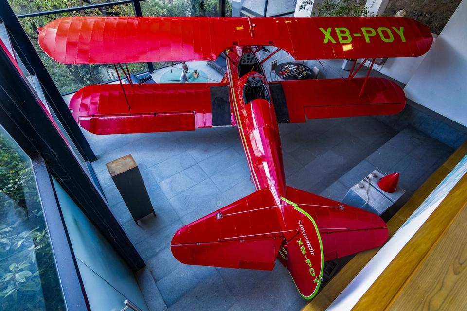 Vista desde la planta alta hacia la avioneta roja en la doble altura