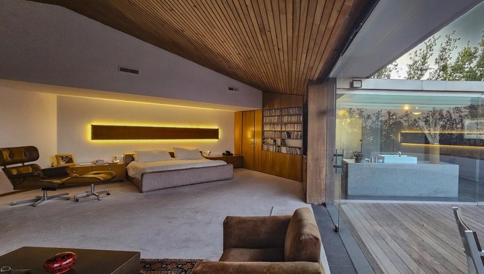 Recámara con techo de madera abierta al baño y la terraza