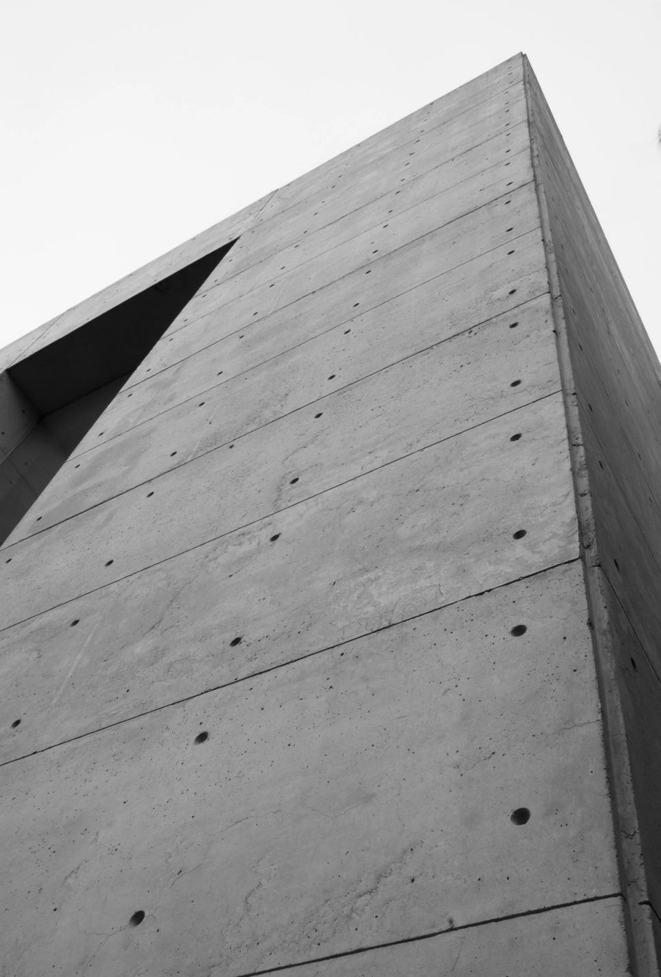 Esquina del volumen de concreto aparente contra el cielo, en blanco y negro