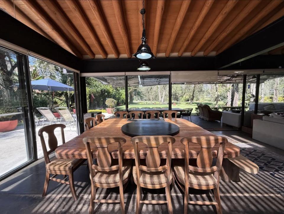 Comedor bajo vigas de madera con vista al jardín y la terraza