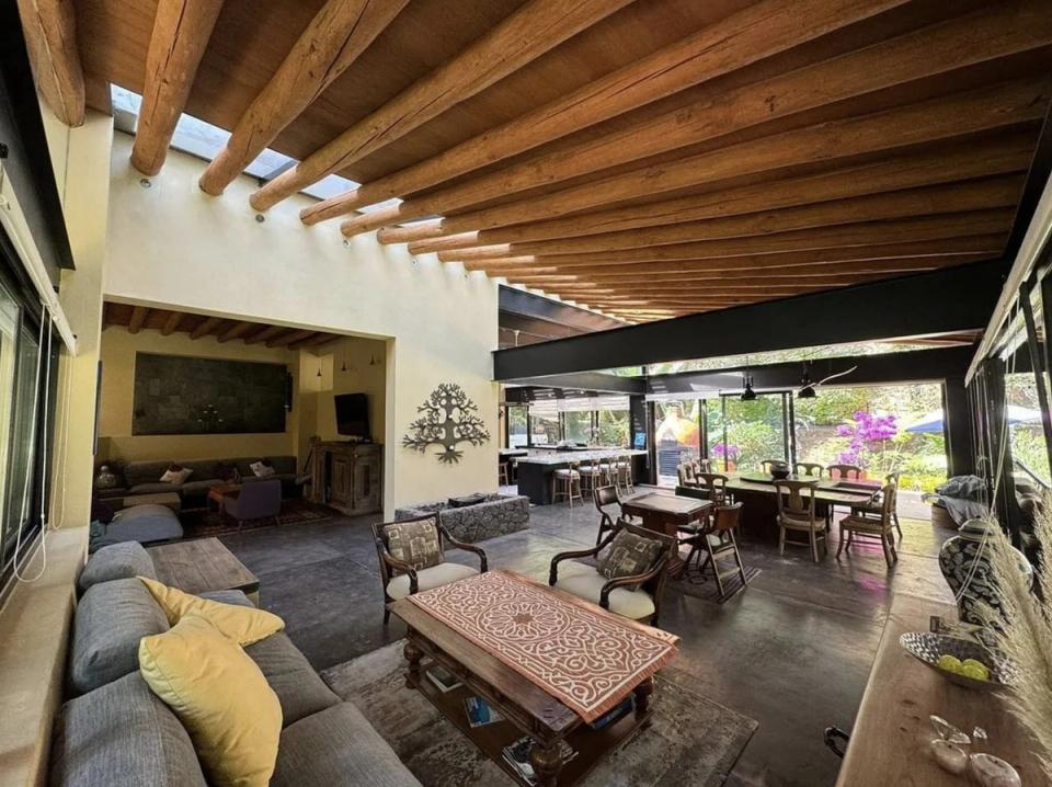 Estancia y comedor bajo techo de vigas de madera y tragaluces