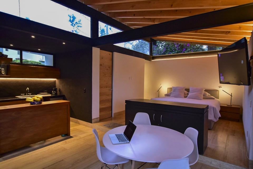 Cocineta y recámara bajo techo de madera con ventanas altas