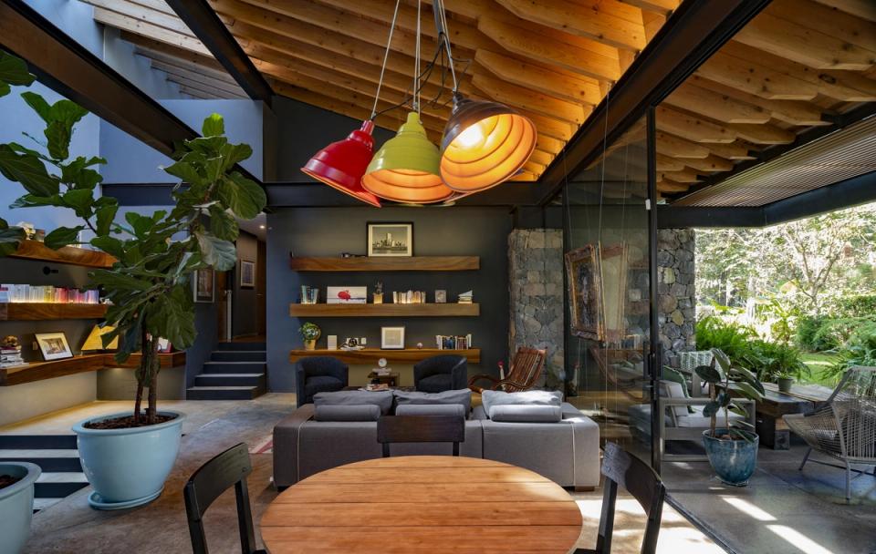 Sala bajo techo de madera con lámparas de colores y libreros