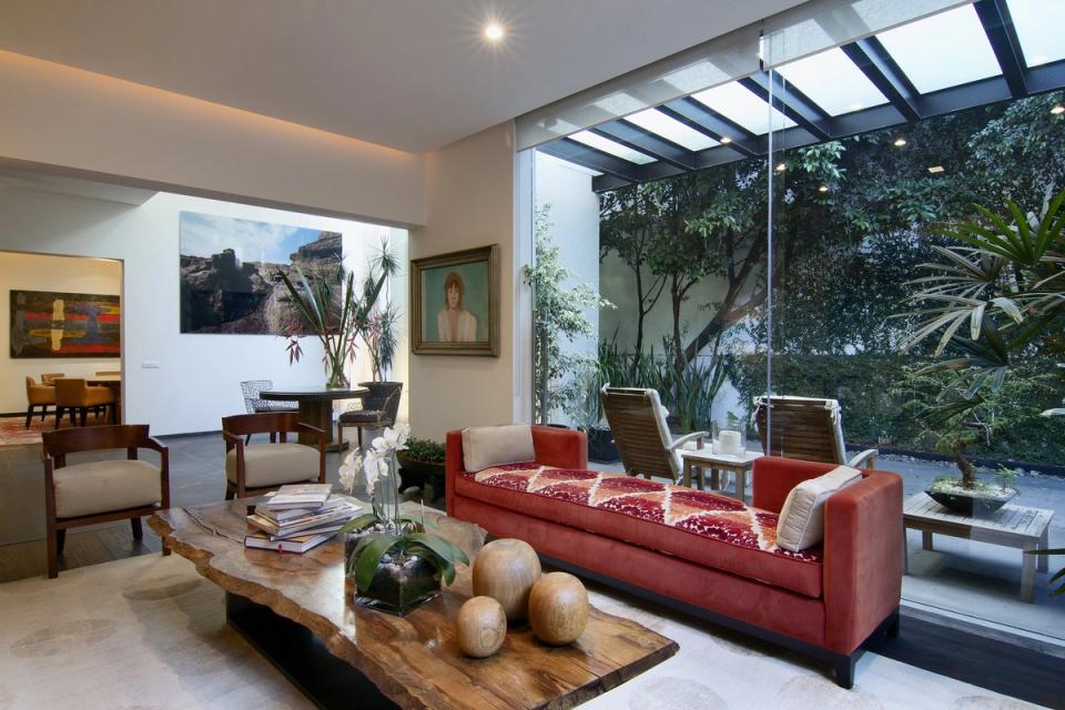 Estancia con sofá rojo y jardín interior