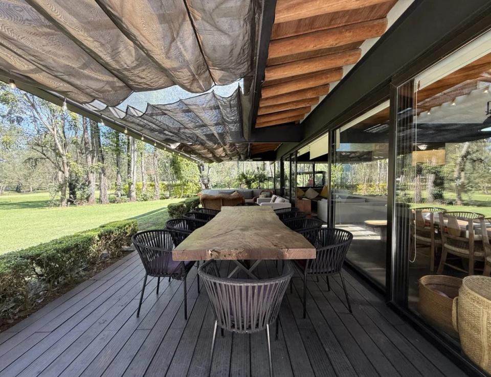 Comedor exterior bajo toldos, junto a la fachada de cristal