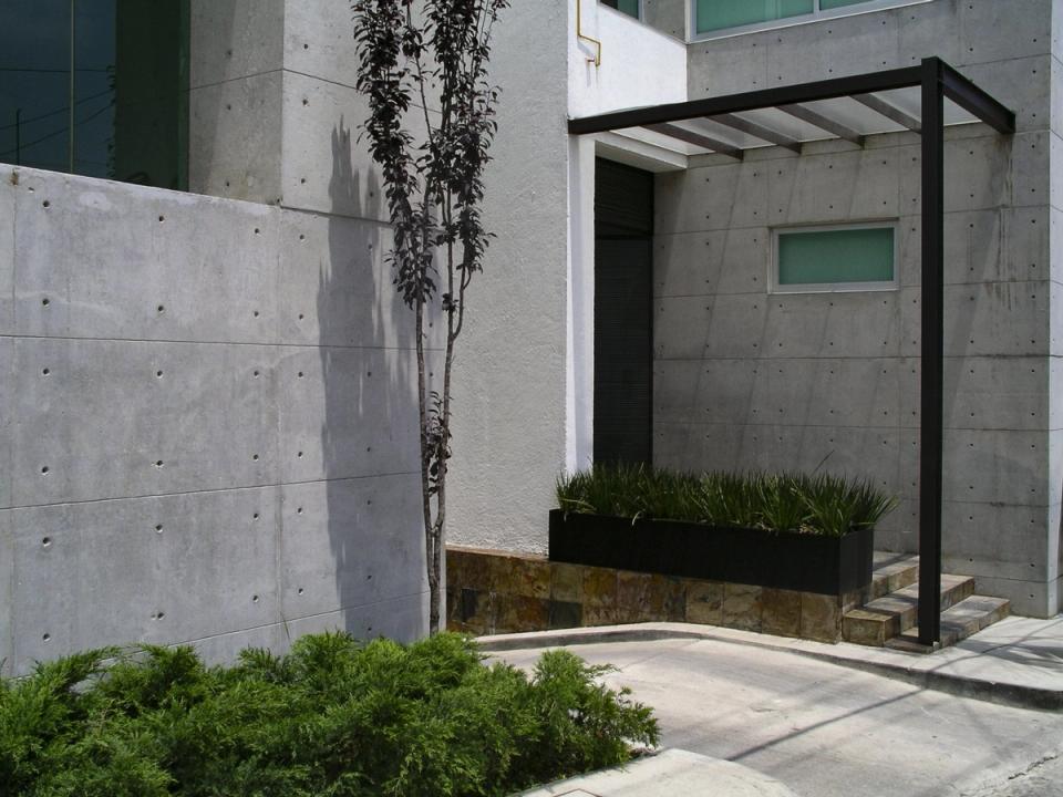 Acceso con pérgola de acero y jardinera