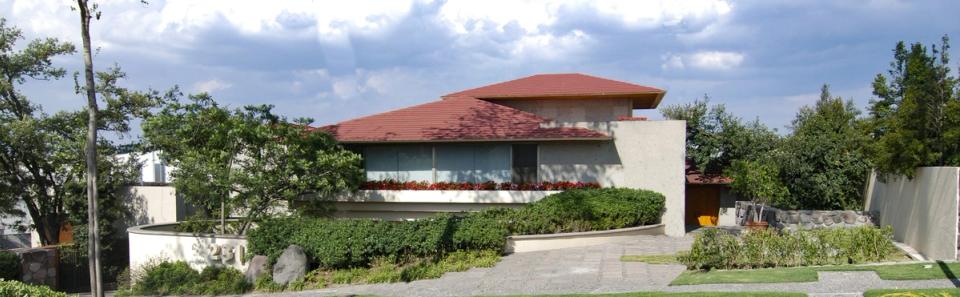 Casa de techos rojos con jardín al frente