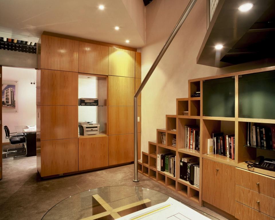 Gabinetes de madera y escalera de libreros bajo el tapanco