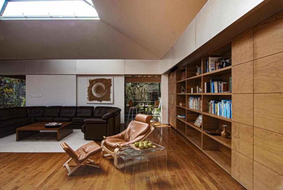 Estancia con librero de madera y sillones de piel