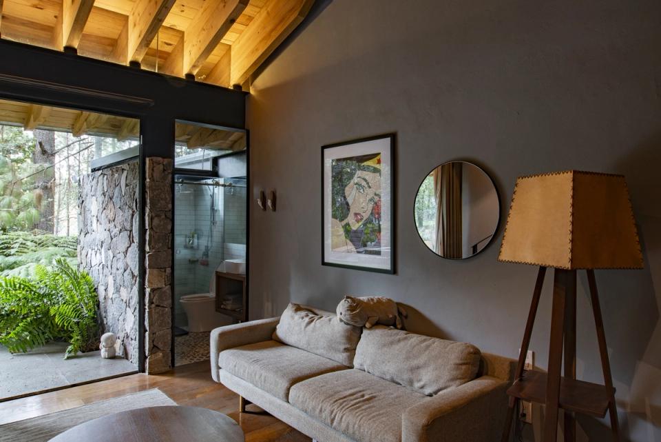 Sala de estar con sofá claro, lámpara de pie y muro gris