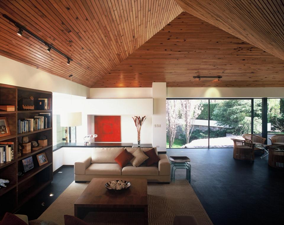 Estancia con techo de madera y vista al jardín