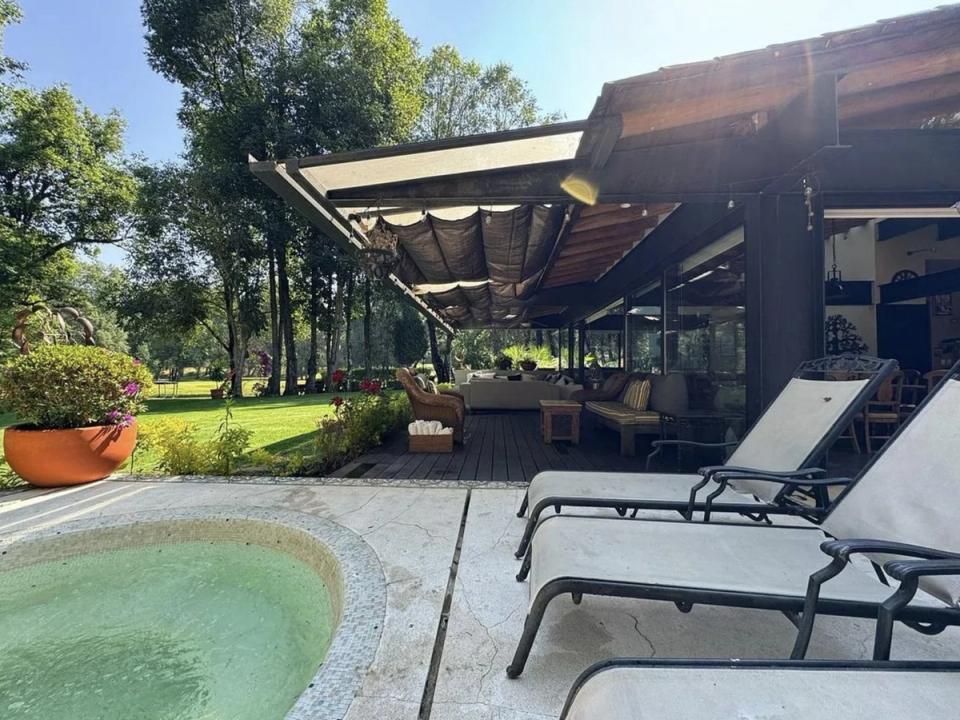 Terraza con alberca redonda y camastros junto al jardín