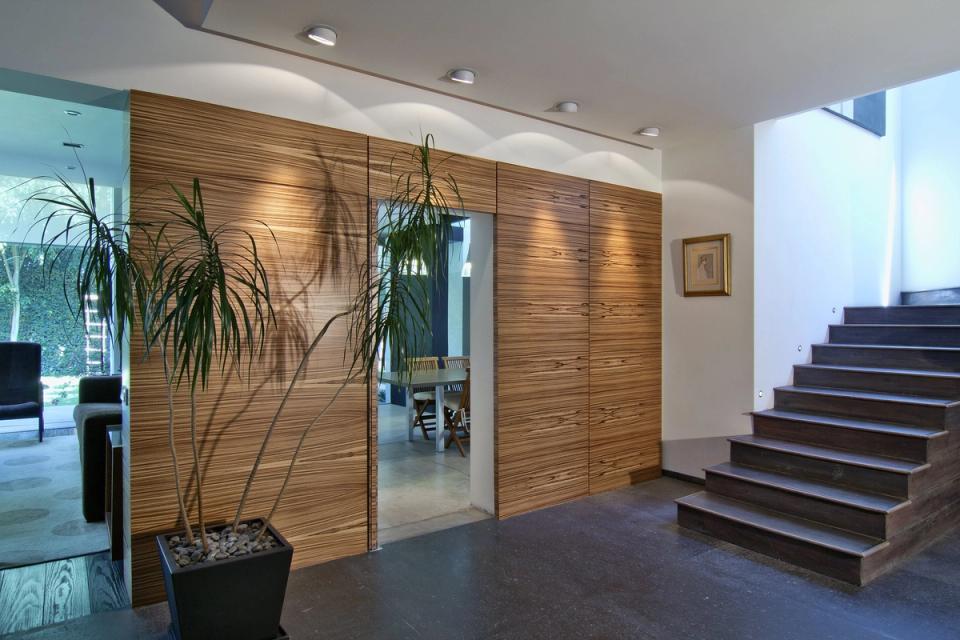 Muro de madera con una puerta abierta junto a la escalera