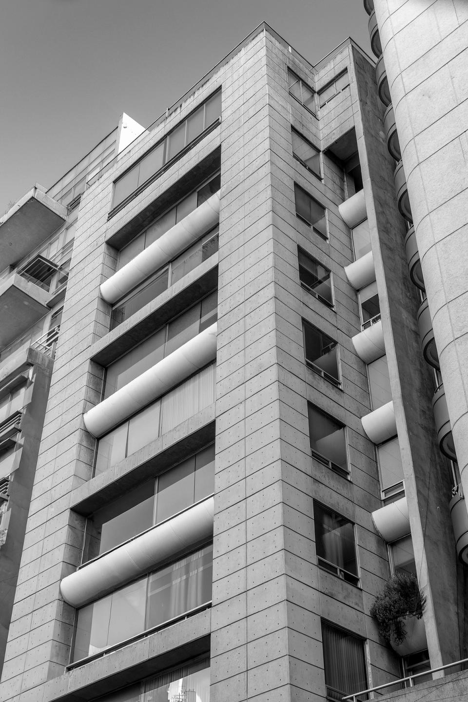 Fachada de la torre en blanco y negro con jardineras curvas