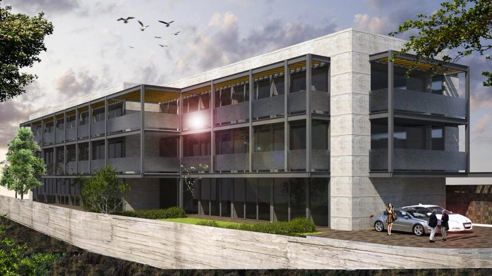 Edificio con balcones de acero y pérgolas sobre un muro de contención