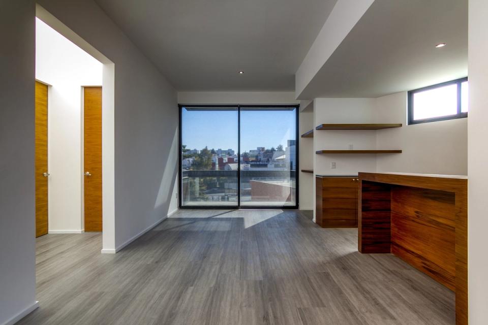 Estancia con ventanal de piso a techo, repisas y barra de madera