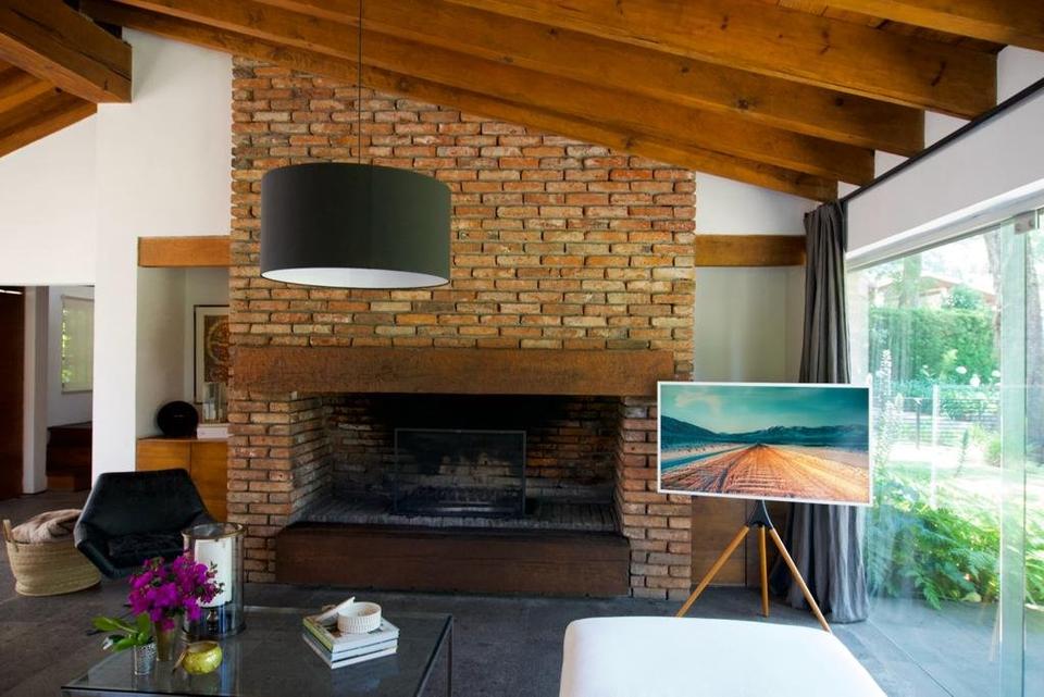 Muro de ladrillo con chimenea bajo el techo de vigas a dos aguas