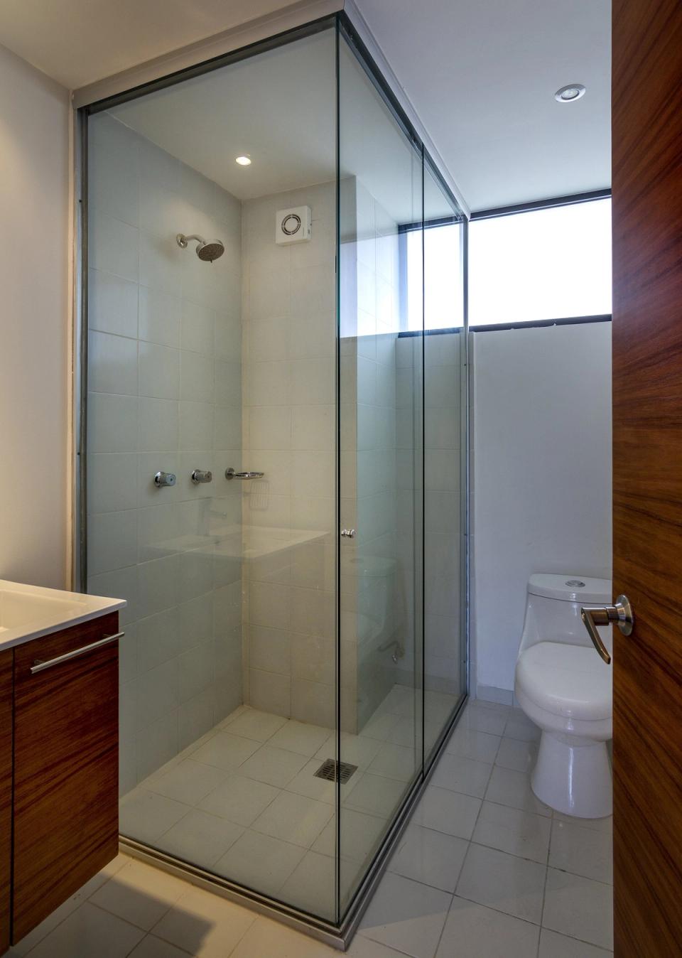 Baño con cancel de vidrio y ventana alta