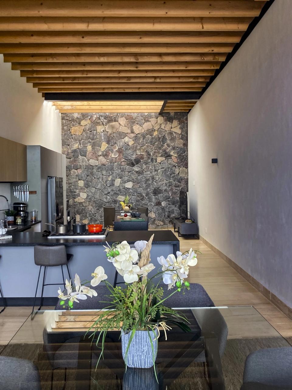 Cocina y comedor frente a un muro de piedra