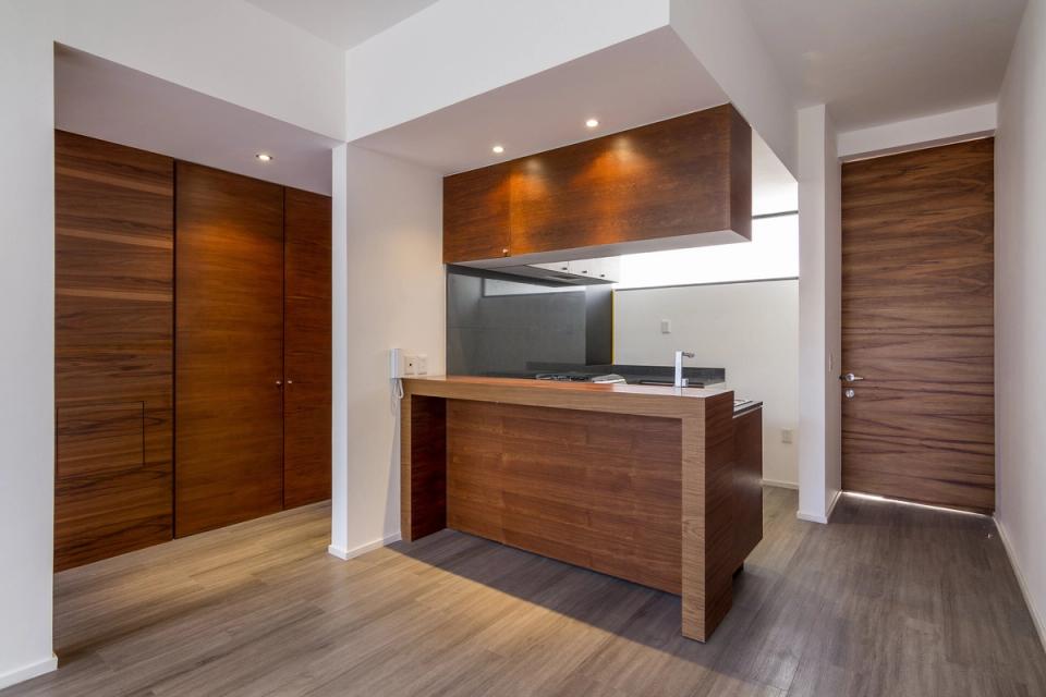Cocina con barra y muro de closets de madera