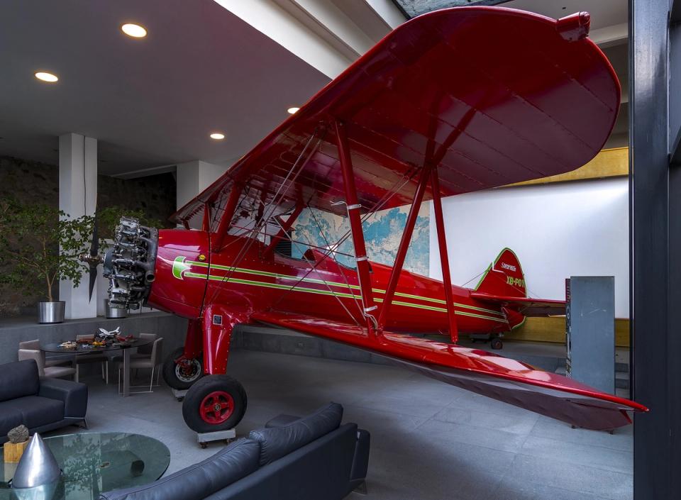 Avioneta roja junto al muro de piedra de la estancia