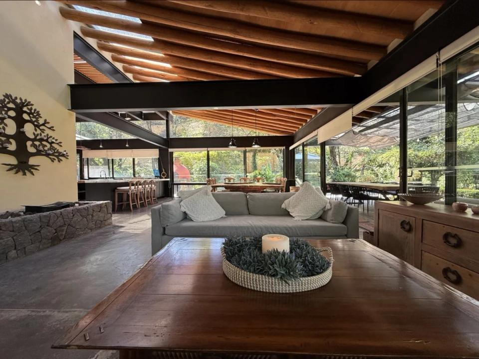 Estancia abierta con fogatero de piedra bajo vigas metálicas y de madera
