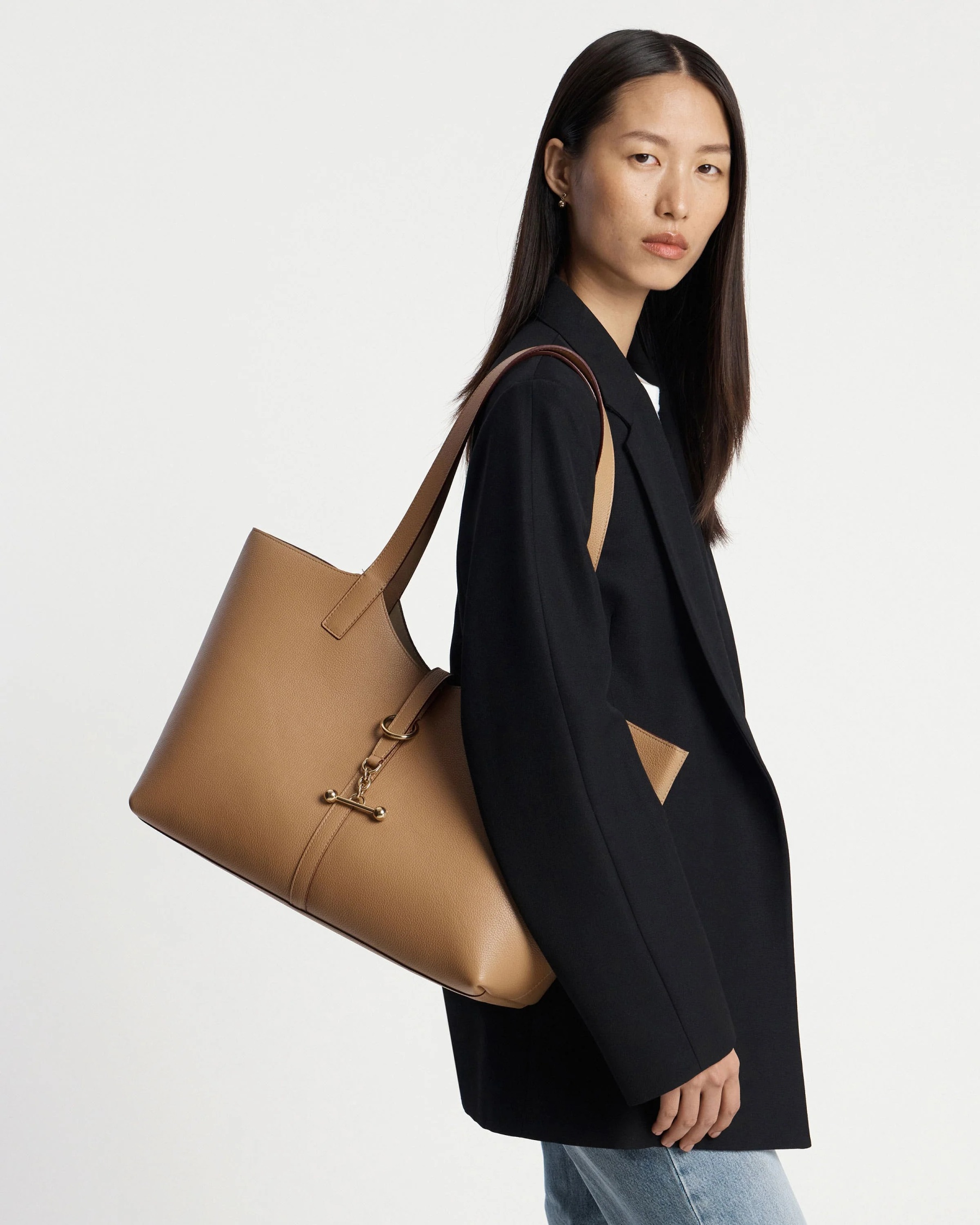 Strathberry model holding a bag