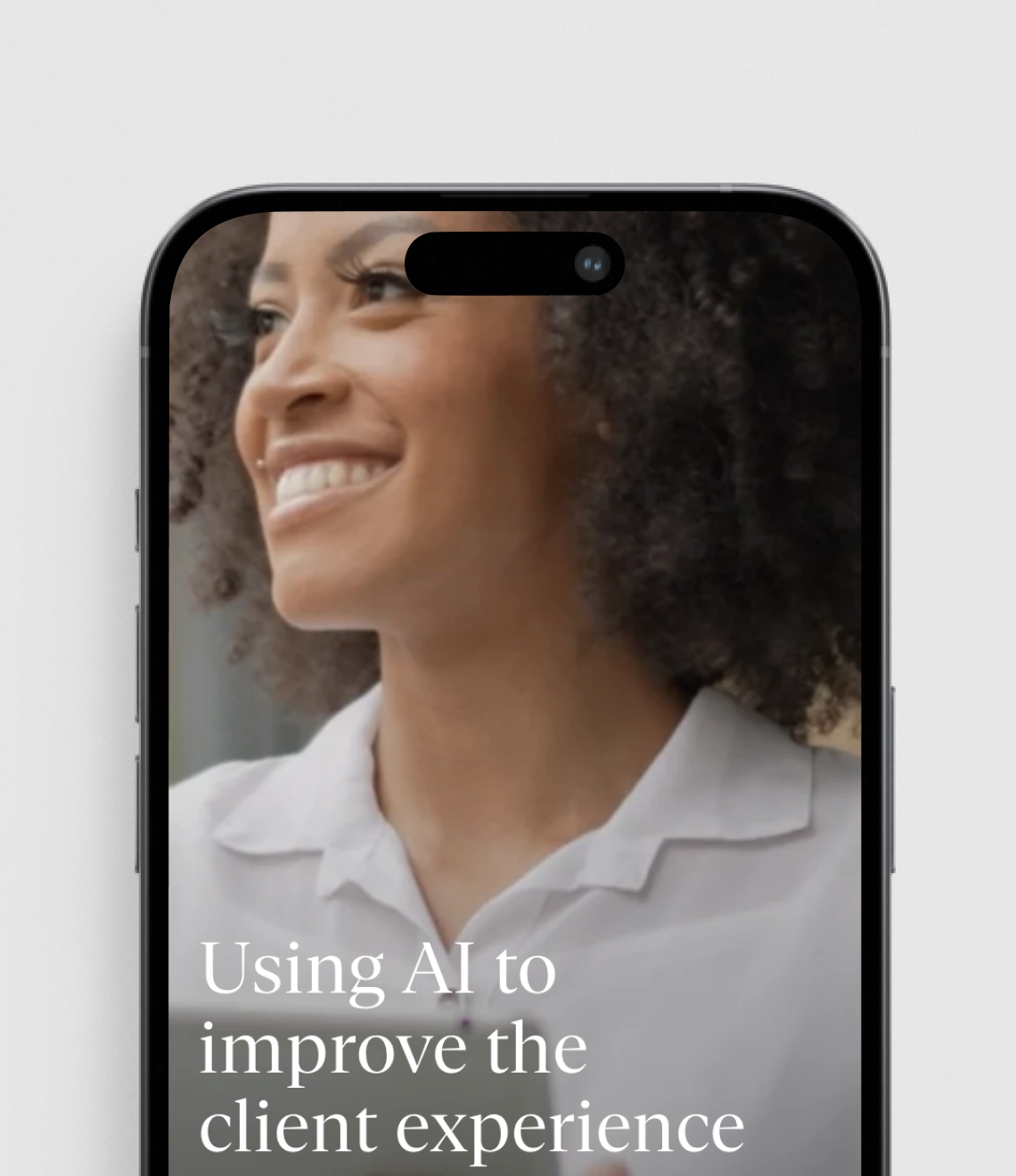 A smartphone screen displays text about "Using AI to improve the client experience" overlaid on an image showing someone with curly hair wearing a white collared shirt.