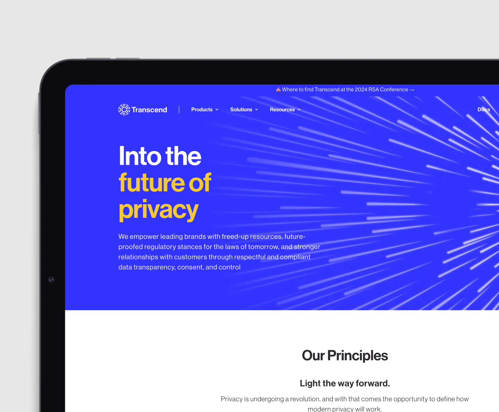 A laptop screen displays Transcend's website homepage featuring their privacy-focused mission statement against a vibrant blue background with radiating light streaks.