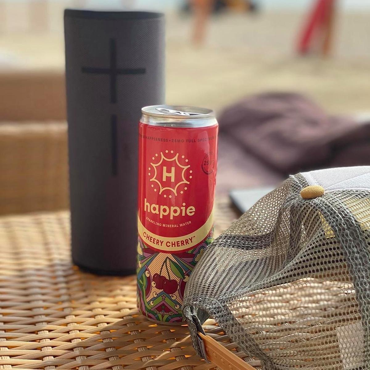 Cheery Cherry can beside a speaker and a mesh beach bag