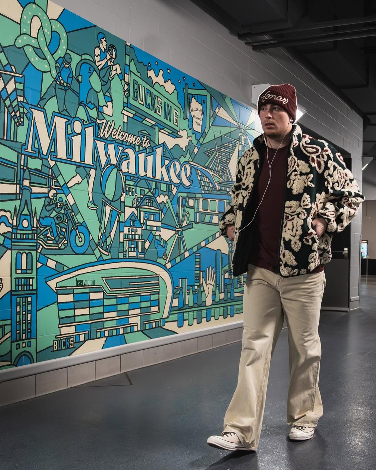 Boston Celtics guard Payton Pritchard walking past the Welcome to Milwaukee mural