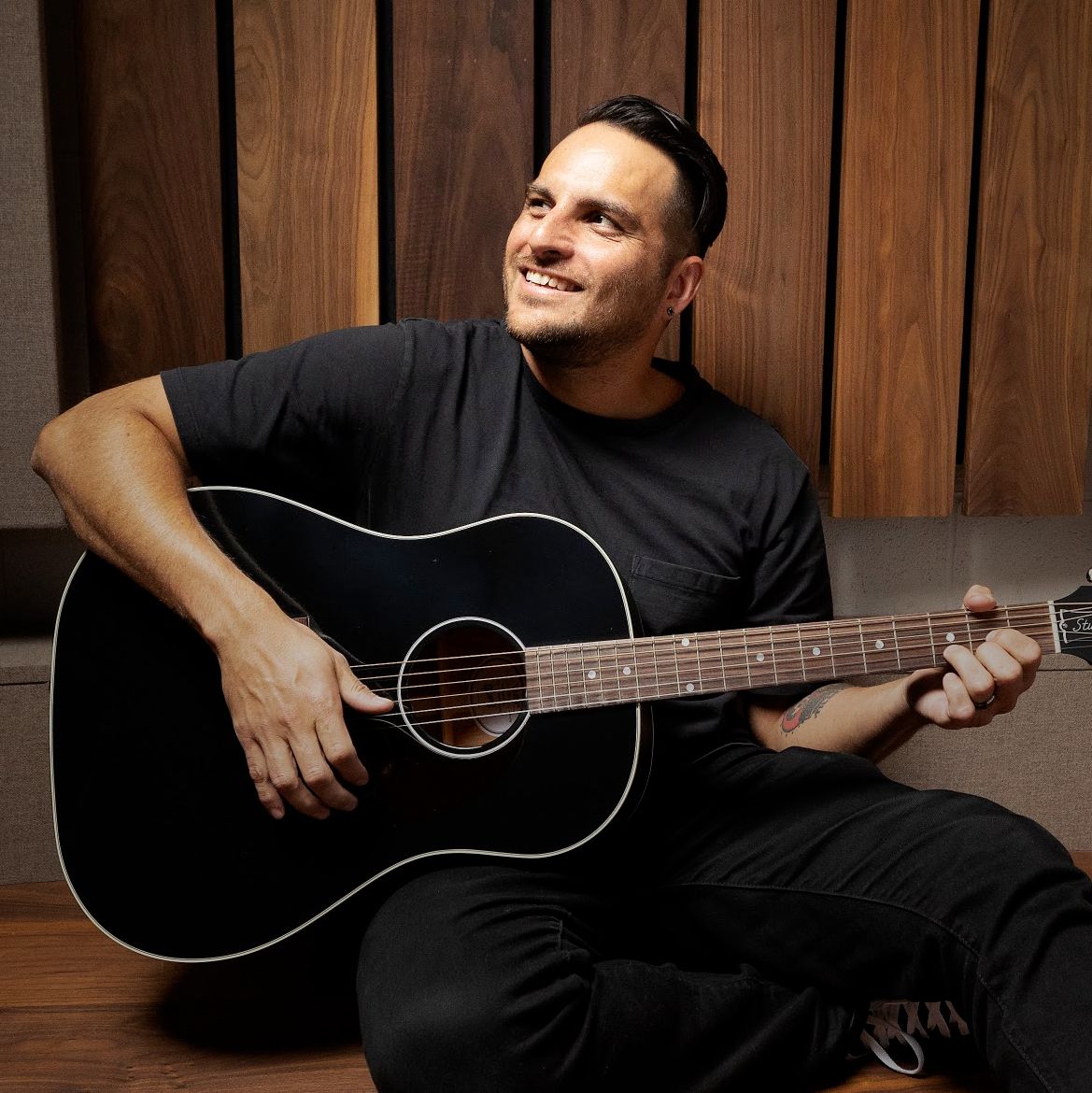 Jon Moreaux, Sr. Manager, Brand Creative at Guitar Center, playing an acoustic guitar
