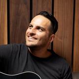 Jon Moreaux, Sr. Manager, Brand Creative at Guitar Center, playing an acoustic guitar